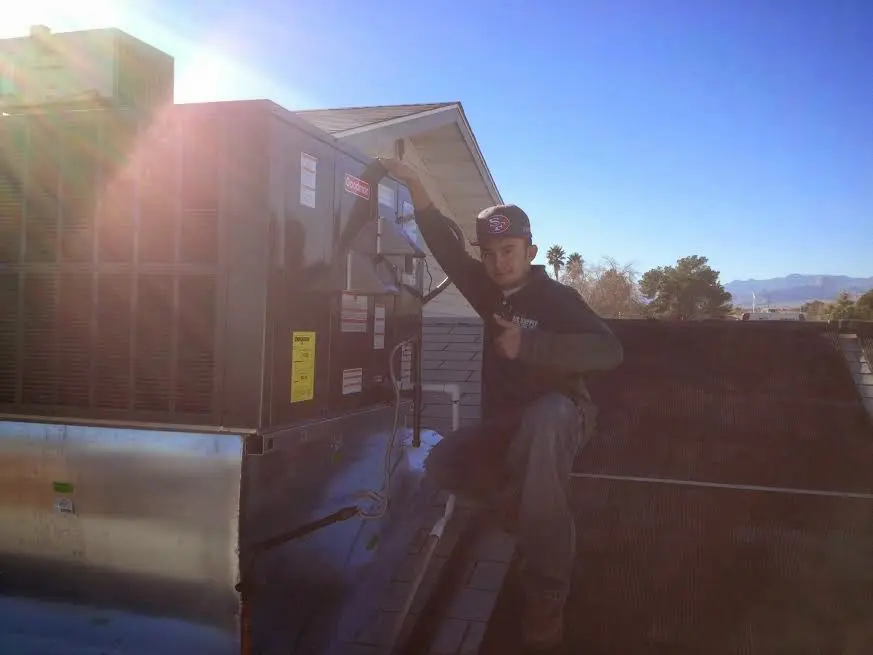 HVAC technician performing Air Duct Cleaning on a rooftop unit in Wesley Chapel